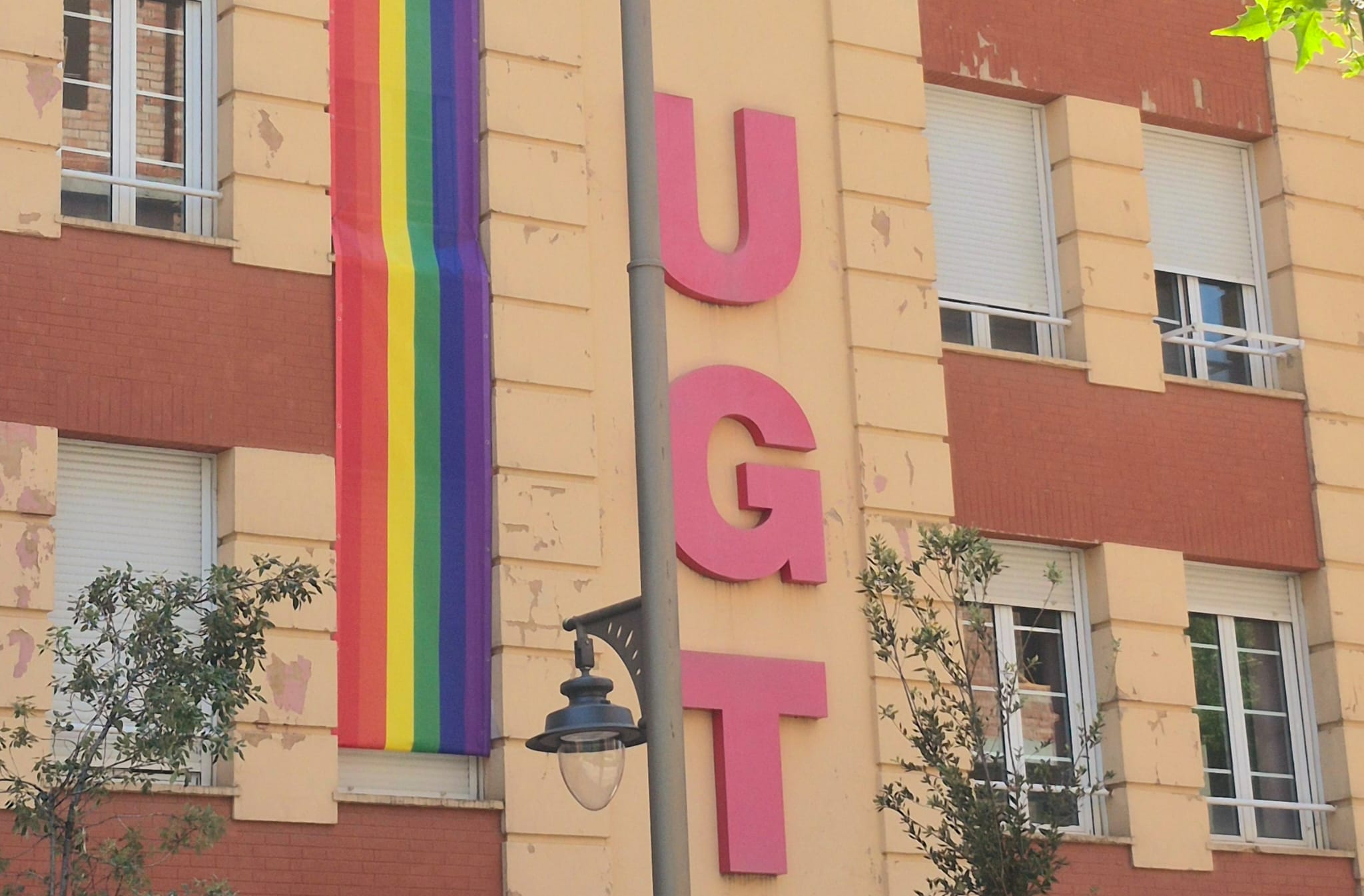 IMAGEN DE LA FACHADA DEL SINDICATO CON LA BANDERA LGTBI